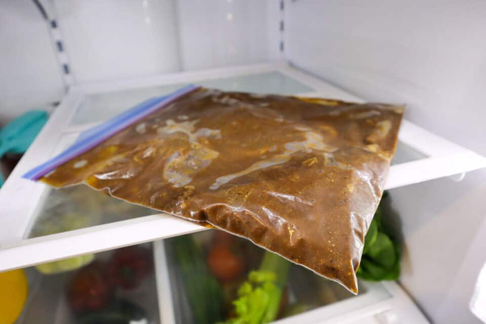 Beef strips in marinade in a zip top bag in the refrigerator.