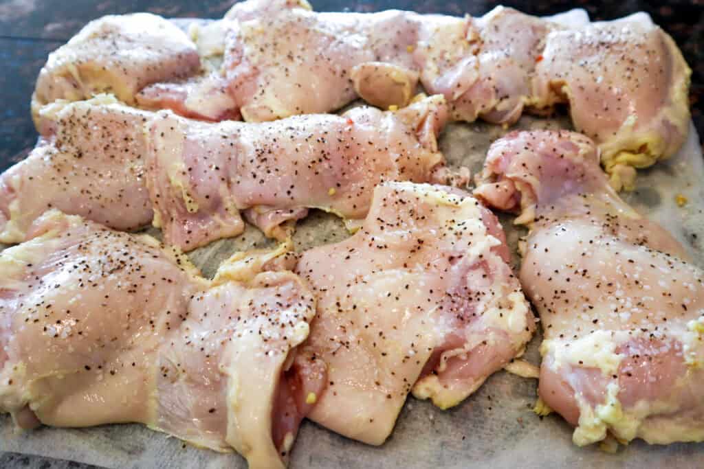 Dill Pickle Marinated Chicken Thighs seasoned with salt & pepper, ready for breading.